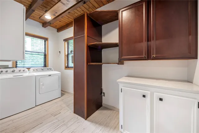 a utility room with cabinets washer and dryer