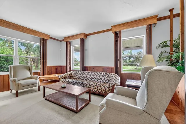 a bedroom with a bed chair and a large window