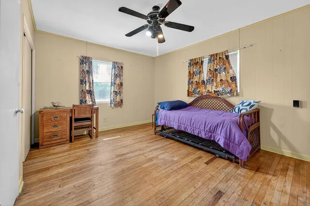 a view of house with a big yard and large trees