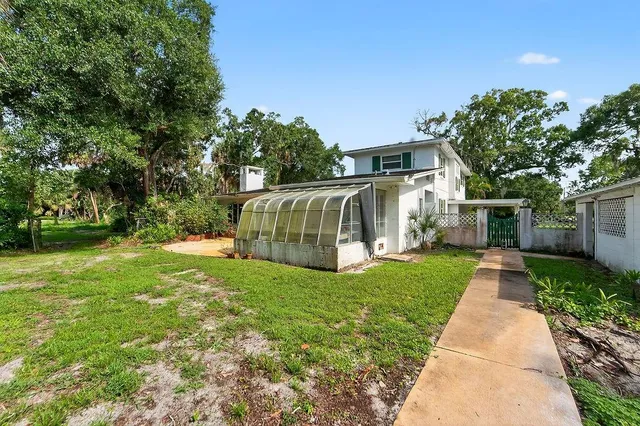 an aerial view of a house with a yard and large tree