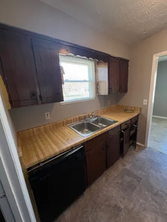 a kitchen with wooden cabinets and a stove top oven