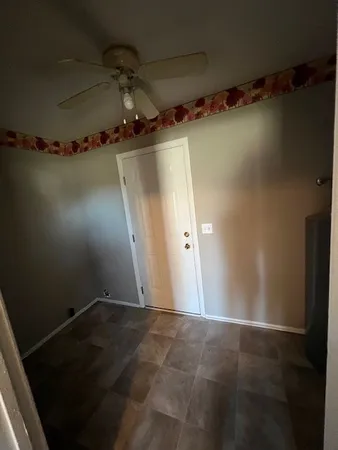 view of a room with water heater and wooden walls