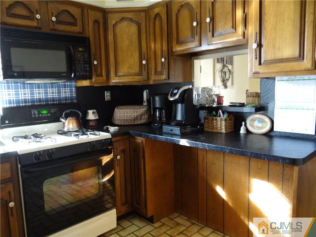 16 Baldwin Road Edison, NJ 08817 - Photo 5 of 12 a kitchen with a stove and a microwave