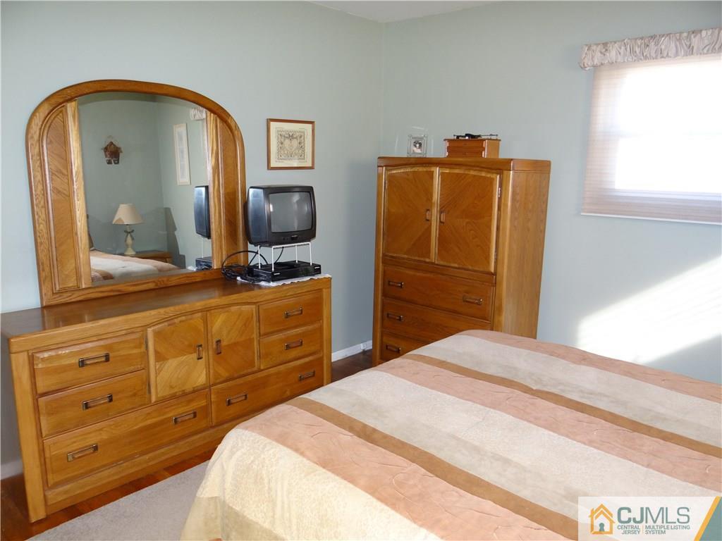 16 Baldwin Road Edison, NJ 08817 - Photo 8 of 12 a bedroom with a bed and a mirror on dresser