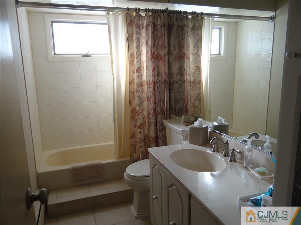 16 Baldwin Road Edison, NJ 08817 - Photo 10 of 12 a bathroom with a granite countertop sink a toilet and shower