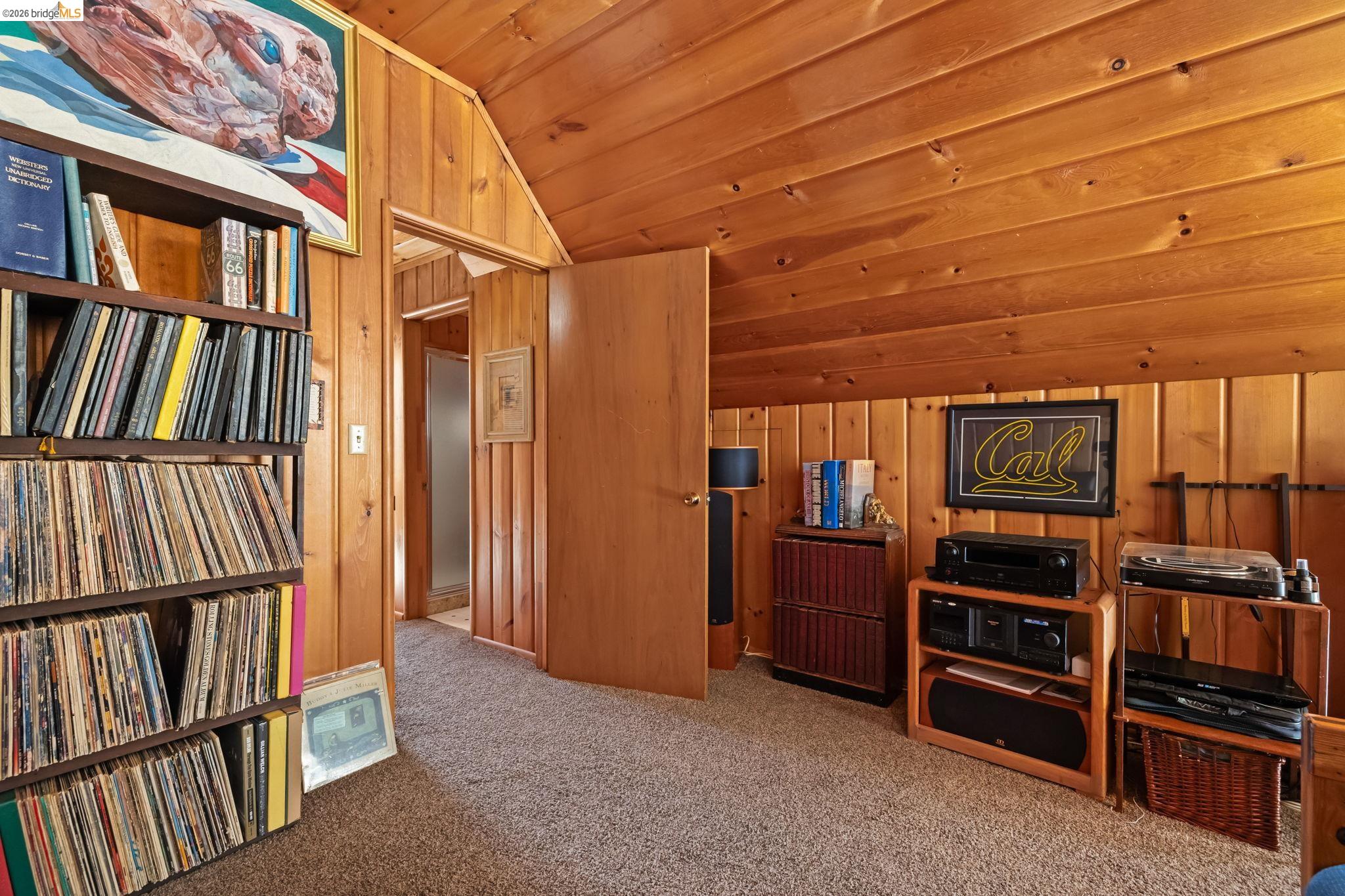 26039 Long Barn Road Long Barn, CA 95335 - Photo 19 of 27 Living area featuring lofted ceiling, wooden ceiling, wood walls, and carpet flooring