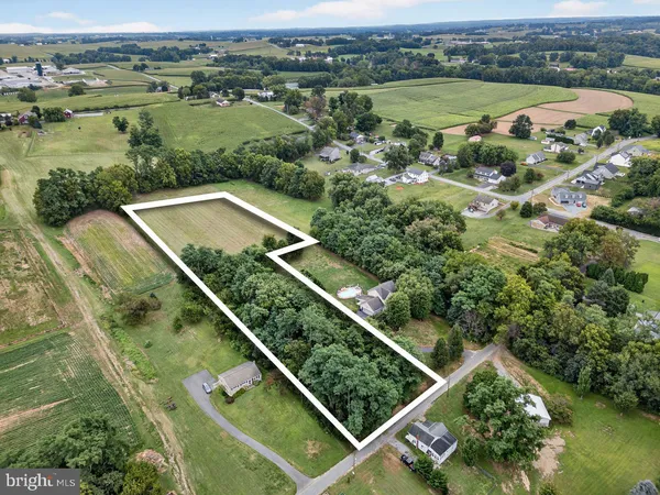 an aerial view of a residential houses with outdoor space and river