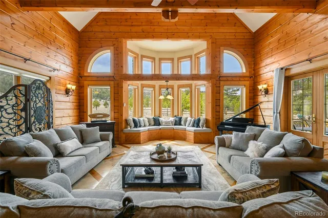 a living room with furniture fireplace and a large window