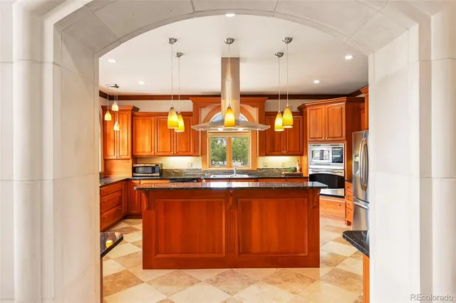 a large kitchen with stainless steel appliances granite countertop a stove and large window