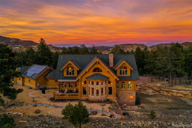 a view of a big house with a big yard and large trees