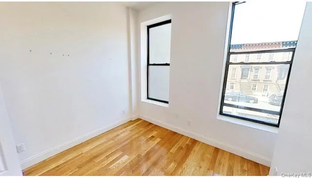 a view of a room with wooden floor and windows