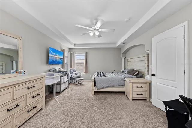 a room with a baby bed and a dresser