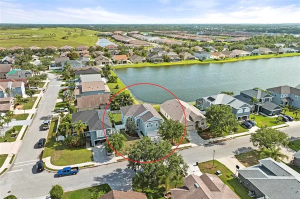 an aerial view of residential houses with outdoor space and lake view