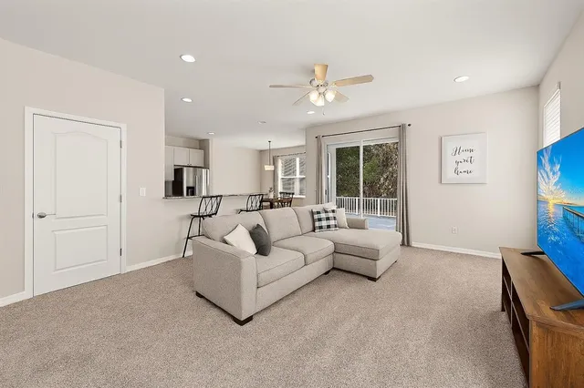 a living room with furniture and kitchen view