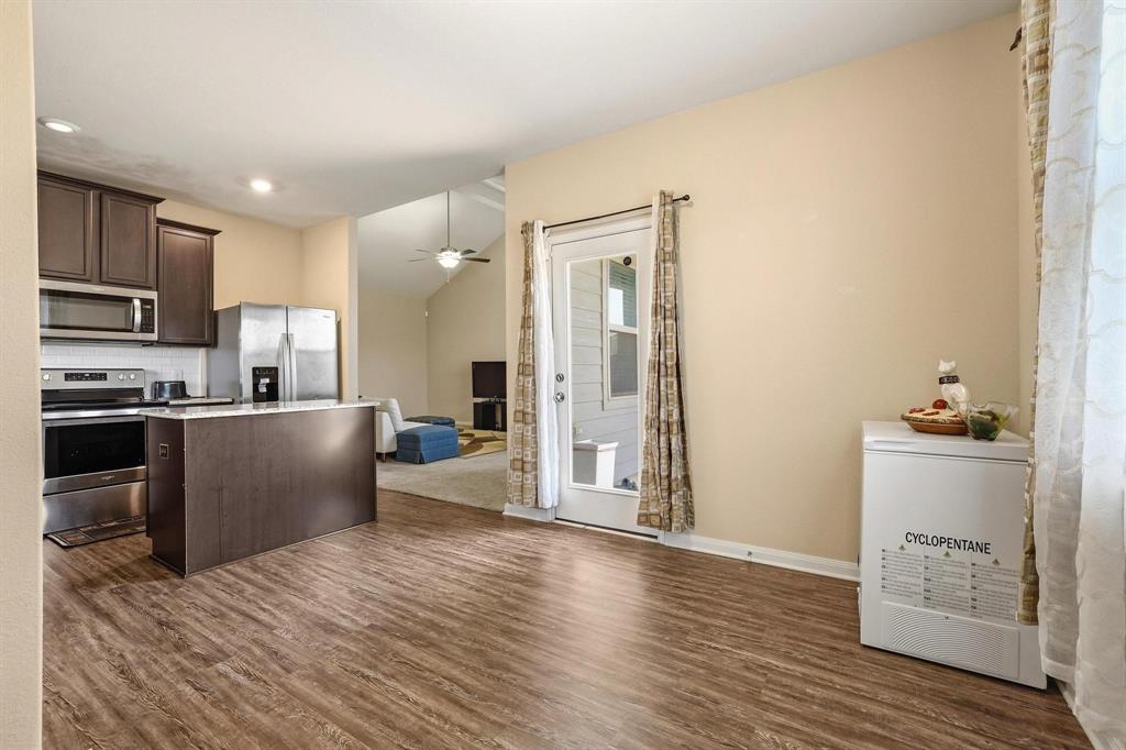 3005 Parker Road Anna, TX 75409 - Photo 8 of 33 Kitchen with dark wood finish cabinets, stainless steel appliances, a center island, light countertops, and a ceiling fan