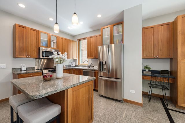 a kitchen with stainless steel appliances granite countertop a sink refrigerator and microwave