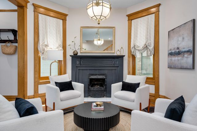 a living room with furniture a fireplace and a large window