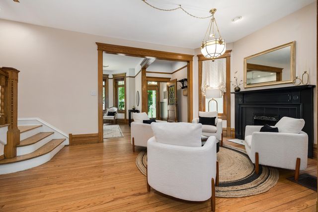 a living room with furniture a chandelier and a fireplace