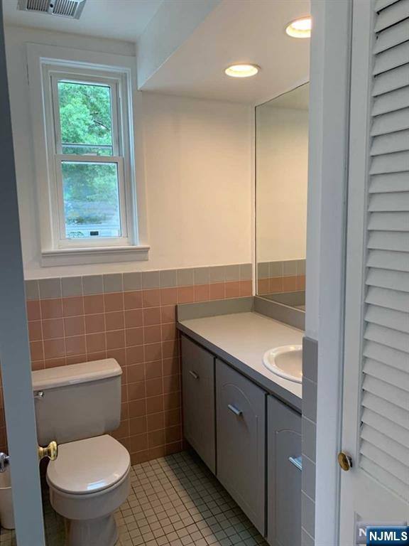 73 East Gouverneur Avenue Rutherford, NJ 07070 - Photo 13 of 33 a bathroom with a granite countertop toilet a sink and a window