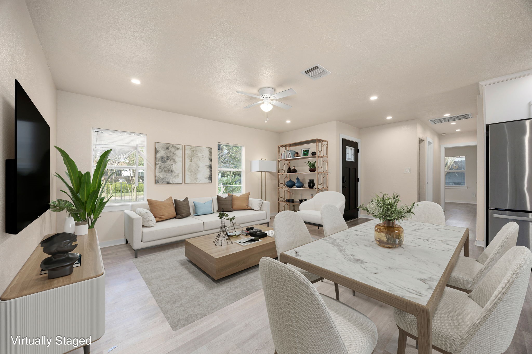 a living room with furniture potted plant a flat screen tv and a potted plant