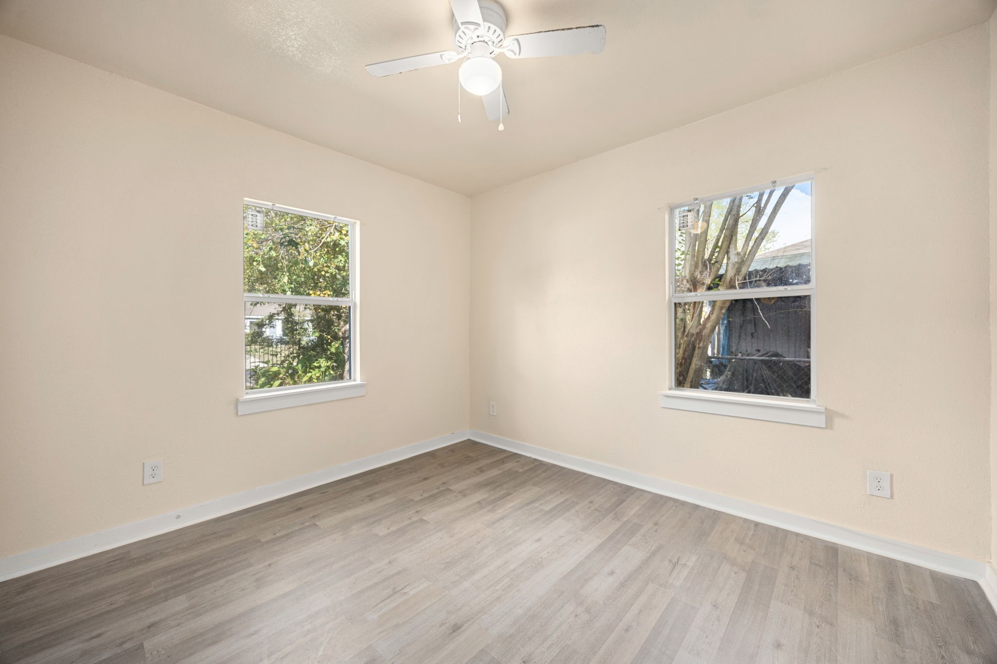 6122 Beldart Street Houston, TX 77033 - Photo 13 of 24 an empty room with wooden floor and windows