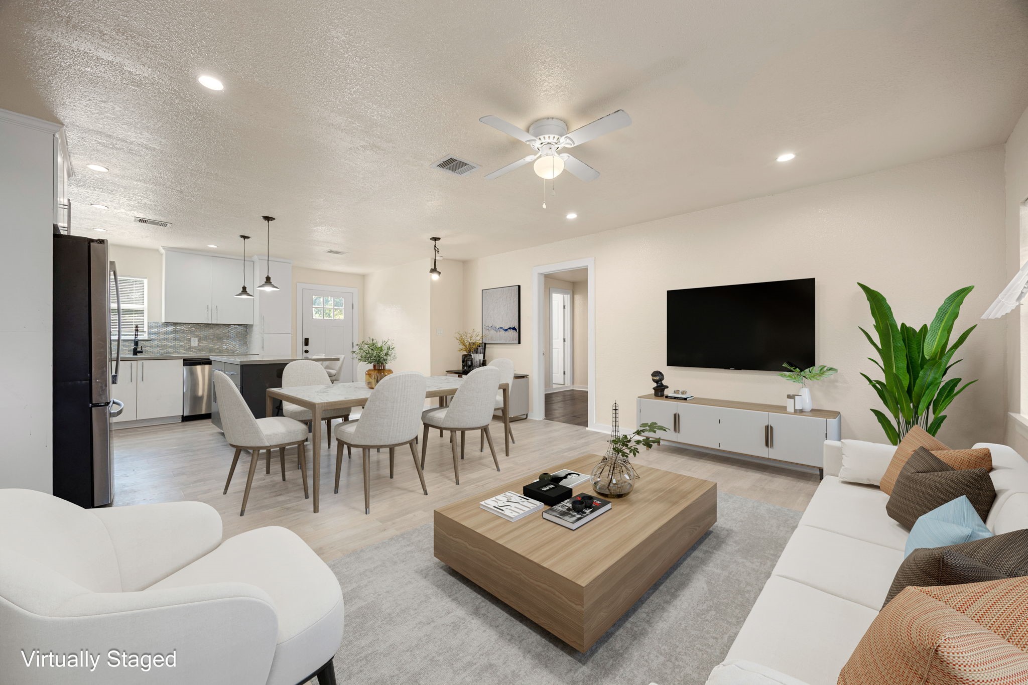 6122 Beldart Street Houston, TX 77033 - Photo 5 of 24 a living room with furniture a flat screen tv and a view of kitchen