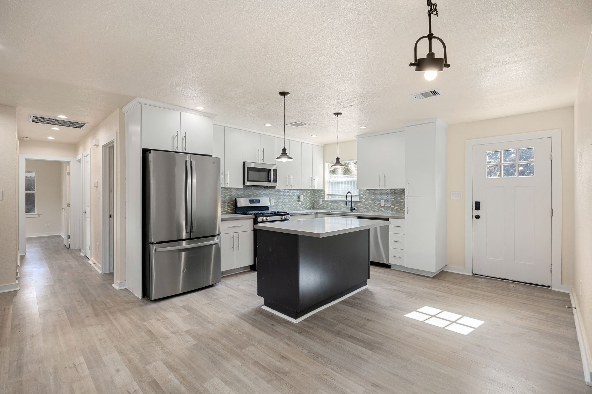 6122 Beldart Street Houston, TX 77033 - Photo 6 of 24 a kitchen with granite countertop a refrigerator and a stove top oven