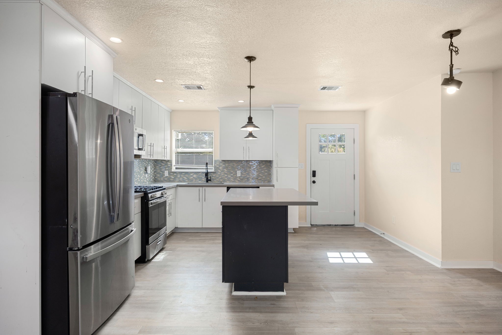 6122 Beldart Street Houston, TX 77033 - Photo 7 of 24 a kitchen with stainless steel appliances granite countertop a refrigerator a sink and white cabinets