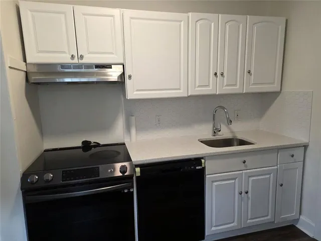 a kitchen with granite countertop a sink and cabinets