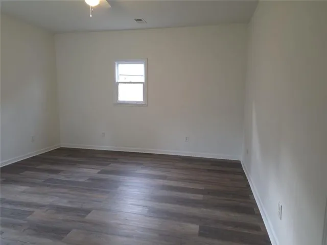 a view of a hallway with wooden floor and window