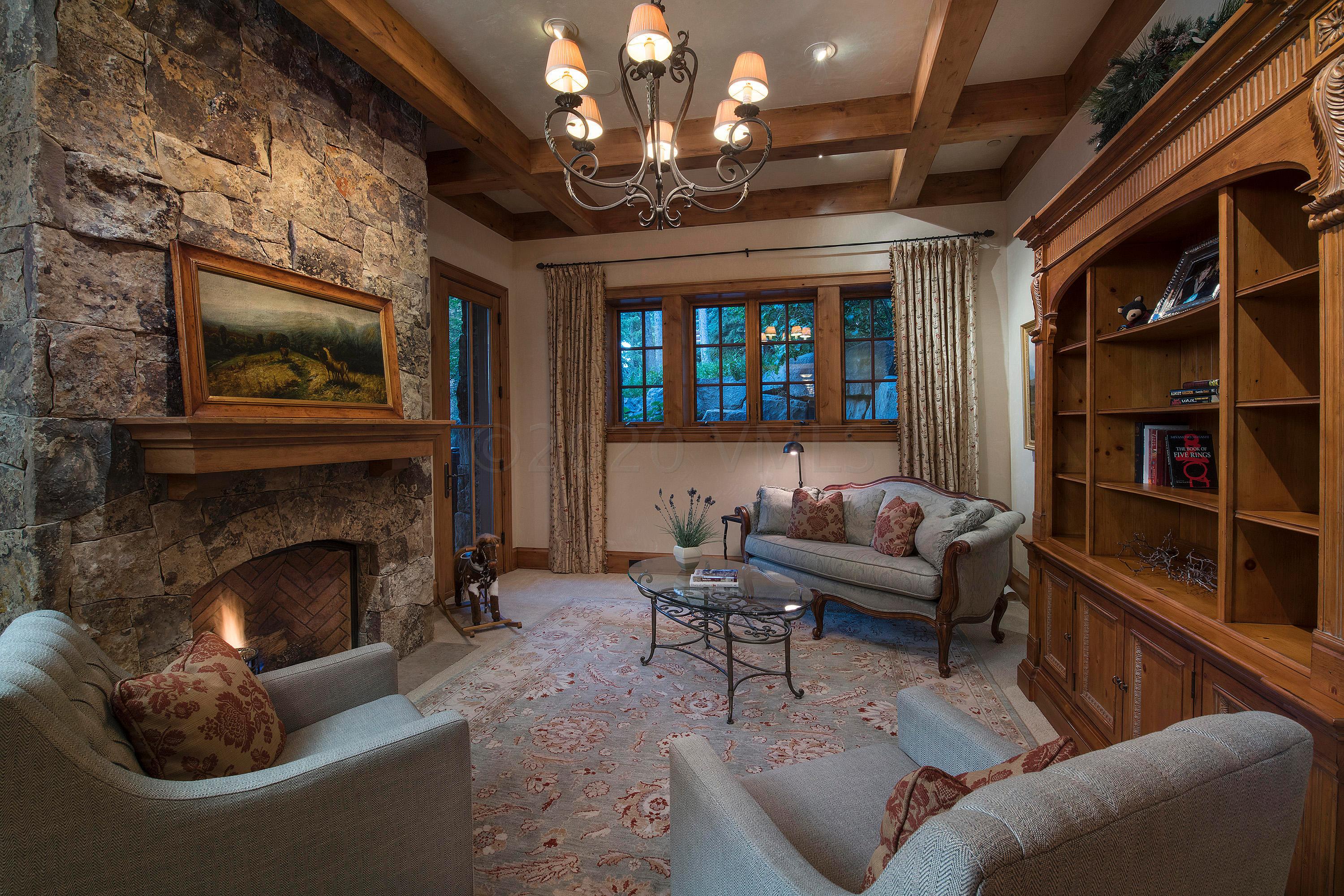 3882 Daybreak Ridge Road Avon, CO 81620 - Photo 22 of 33 a living room with furniture a fireplace and a chandelier