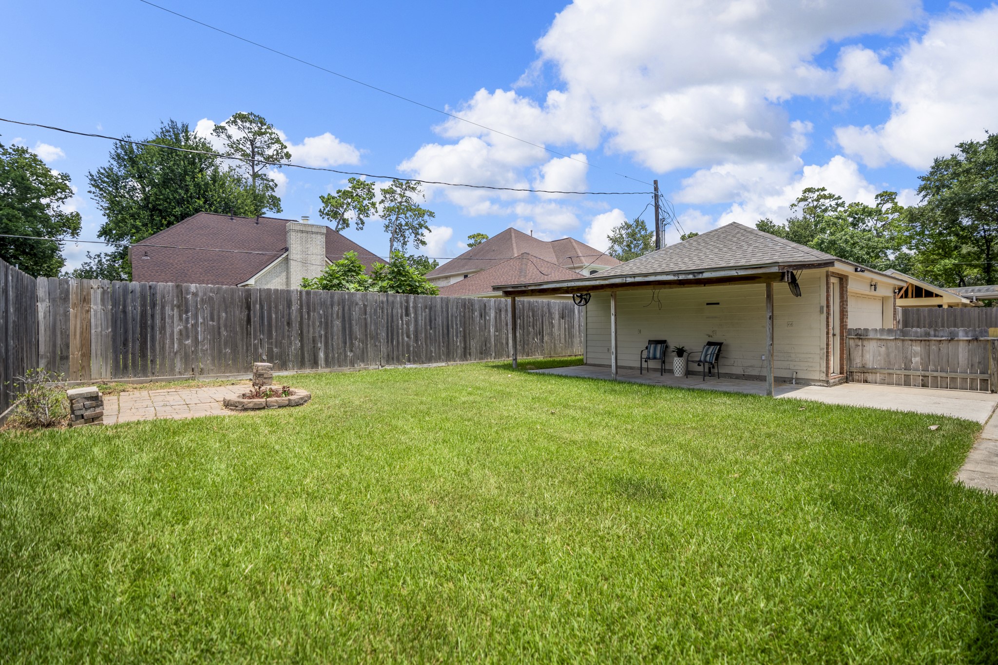 19106 South Rim Trail Spring, TX 77388 - Photo 41 of 50 Out in the backyard, the open lawn gives buyers room to imagine outdoor living beyond the patio. The fenced yard offers space for pets, play, gardening, or future additions, while the view back across the yard shows how much usable outdoor space sits behind the home. With the breakfast area and main living spaces nearby, it’s easy to see everyday life extending outside for grilling, relaxing, and weekend time at home.