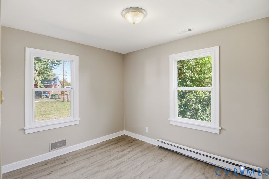 4216 Sheffield Road Richmond, VA 23224 - Photo 13 of 23 a view of an empty room with wooden floor and a window