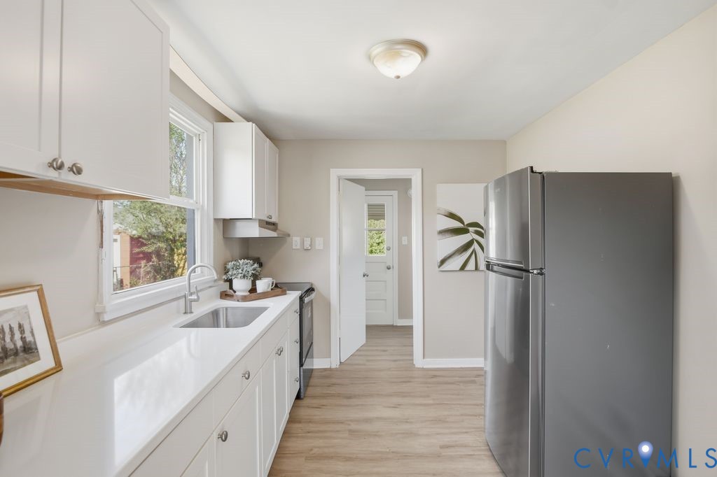 4216 Sheffield Road Richmond, VA 23224 - Photo 8 of 23 a kitchen with a refrigerator a sink and a window