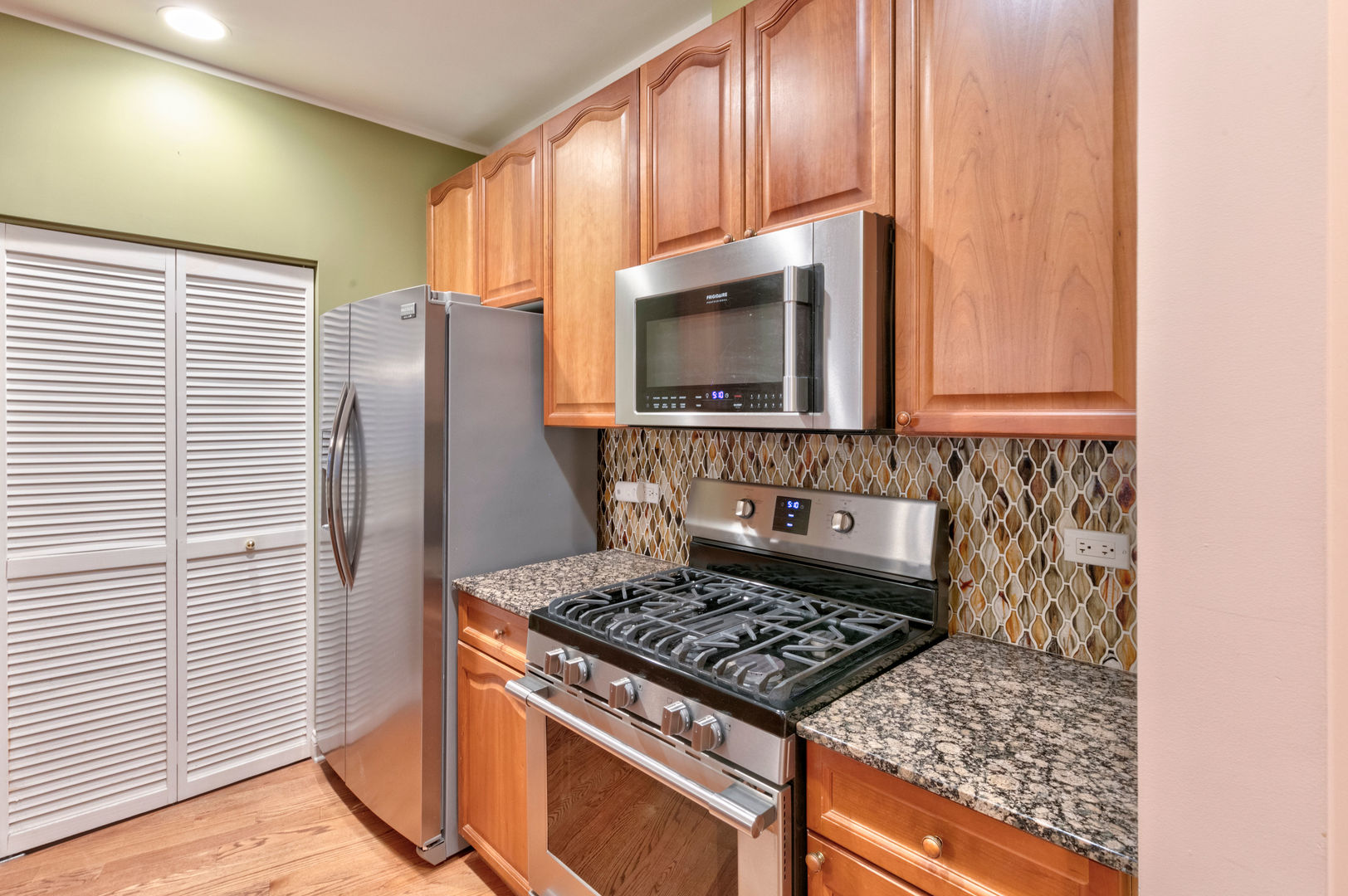 7746 North Sheridan Road, Unit 2L Chicago, IL 60626 - Photo 10 of 22 a kitchen with stainless steel appliances granite countertop a stove a sink and a microwave