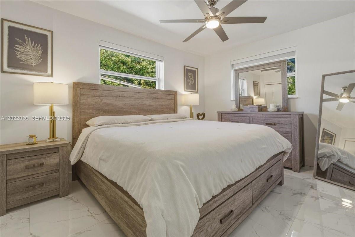 120 West 50th Street Hialeah, FL 33012 - Photo 10 of 22 a bedroom with a bed and a chandelier