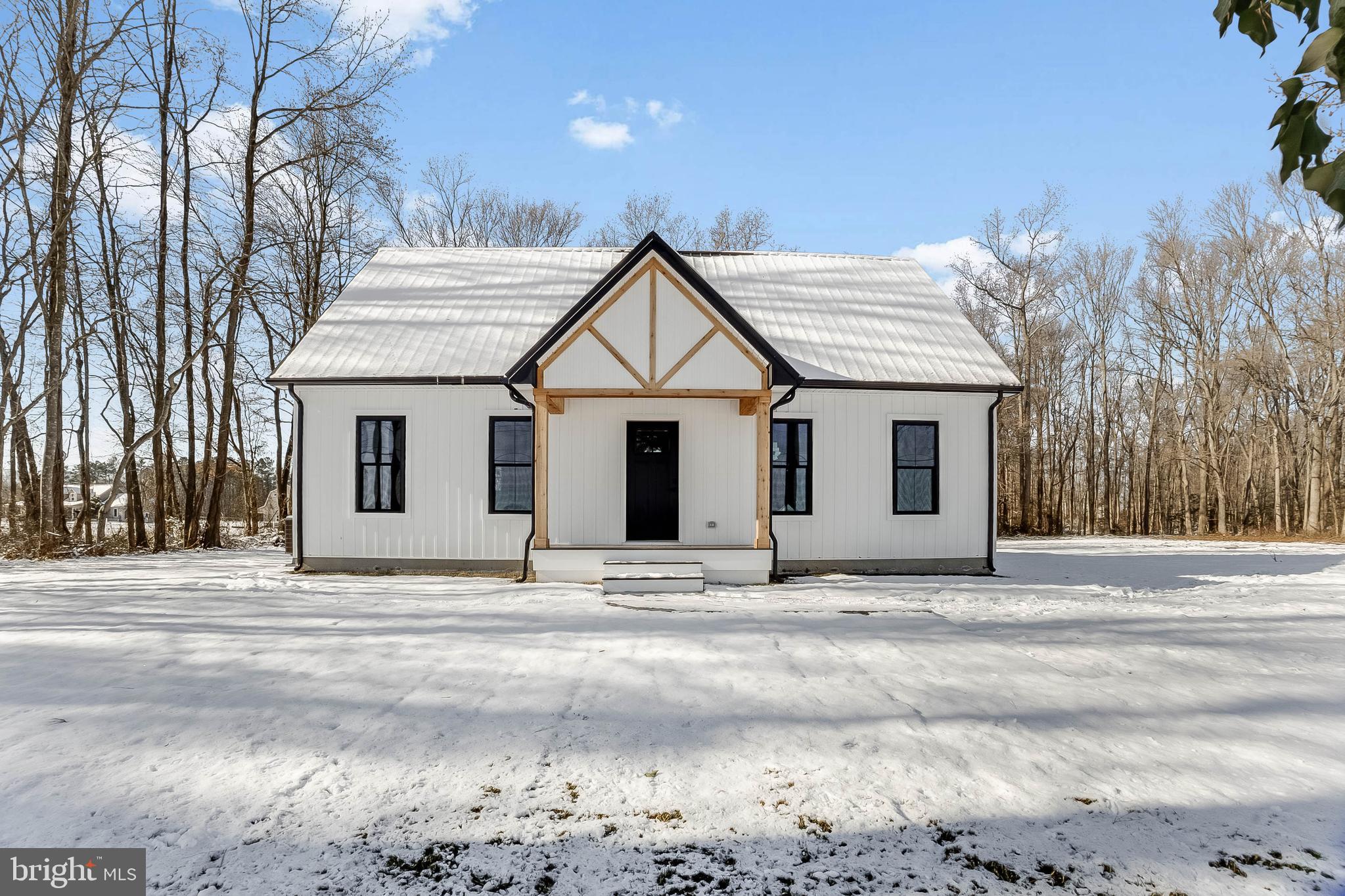 a white house with a large tree in front of it