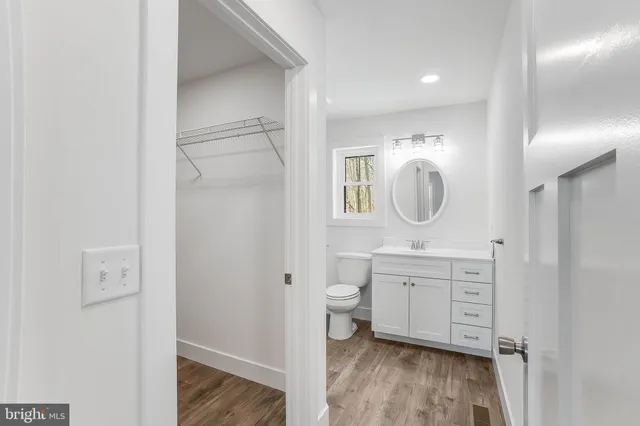 a spacious bathroom with a toilet a sink and a mirror