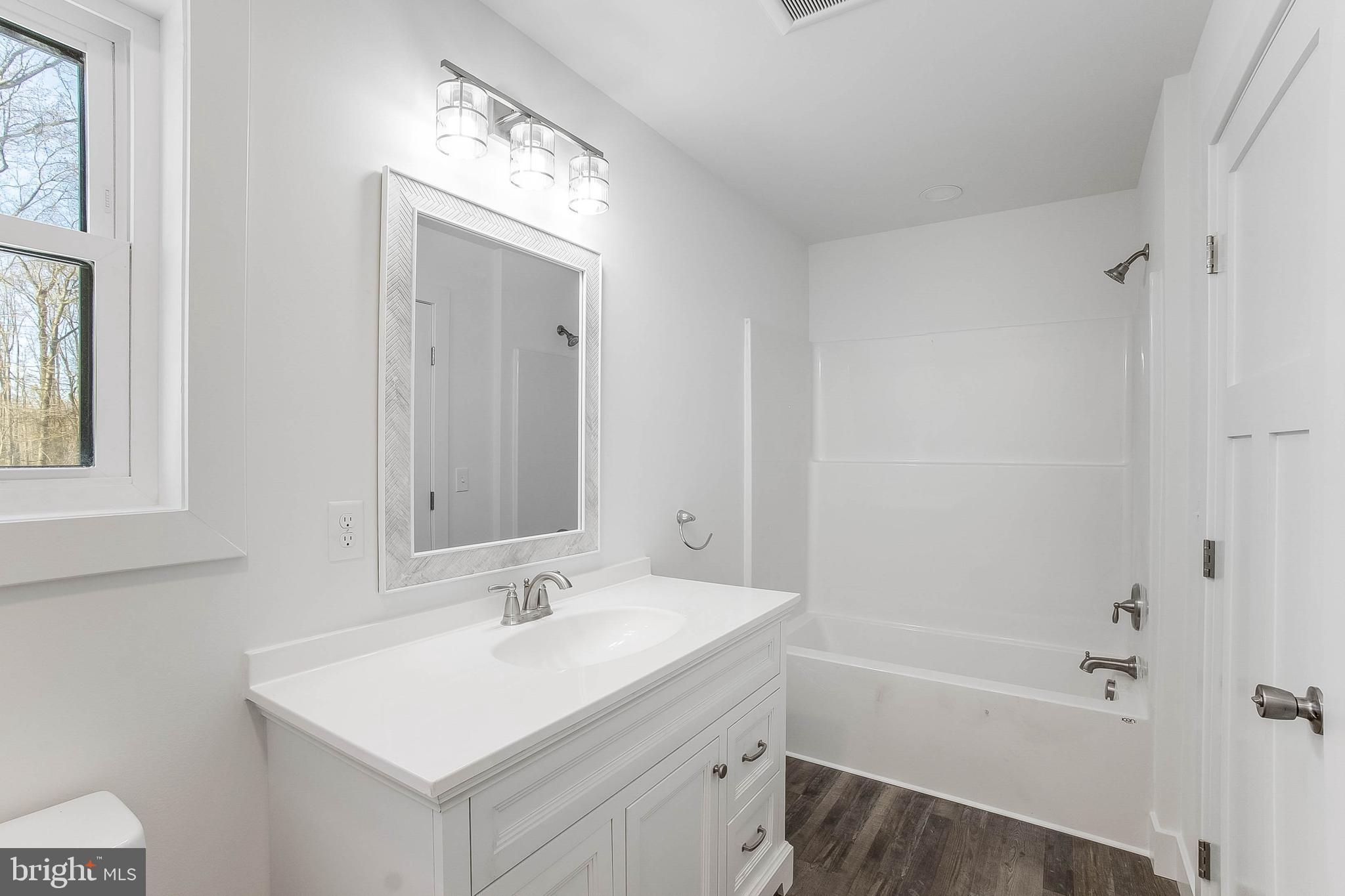 1255 Rose Valley School Road Dover, DE 19904 - Photo 18 of 26 a bathroom with a sink a mirror and a bathtub