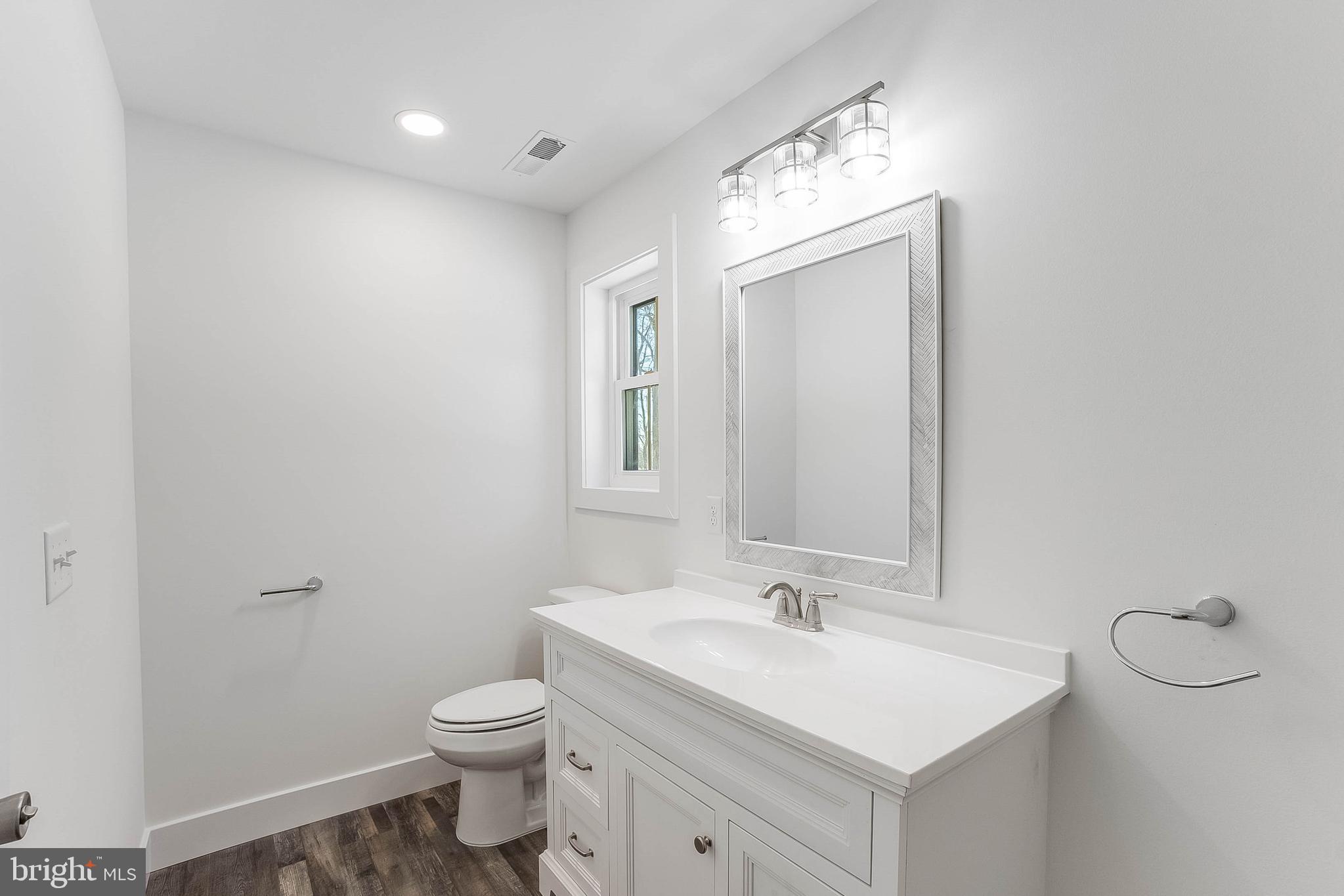 1255 Rose Valley School Road Dover, DE 19904 - Photo 19 of 26 a bathroom with a sink a toilet and a mirror