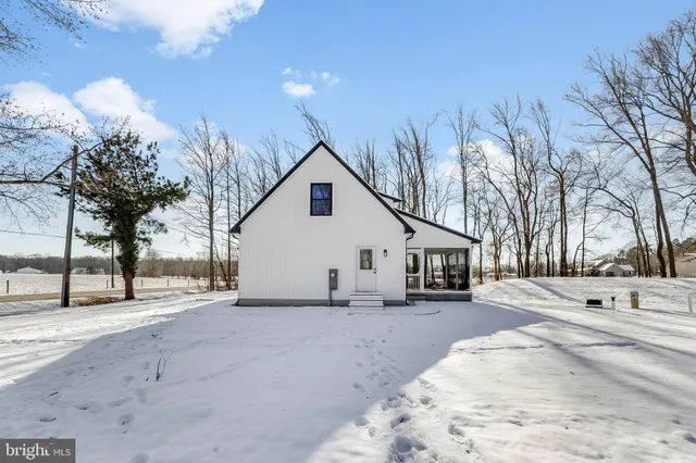 a view of a white house with a snow on the road
