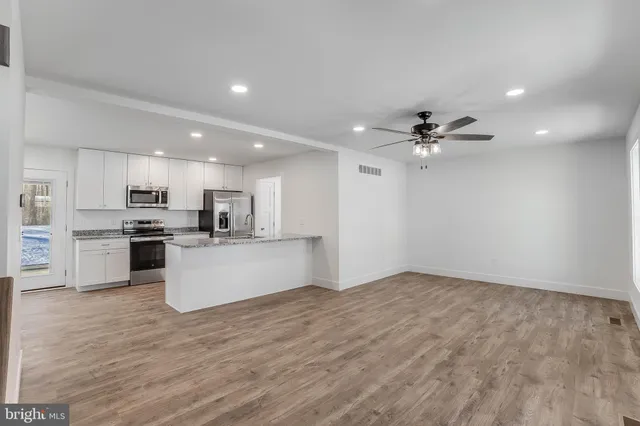 a view of kitchen with refrigerator sink and white cabinets