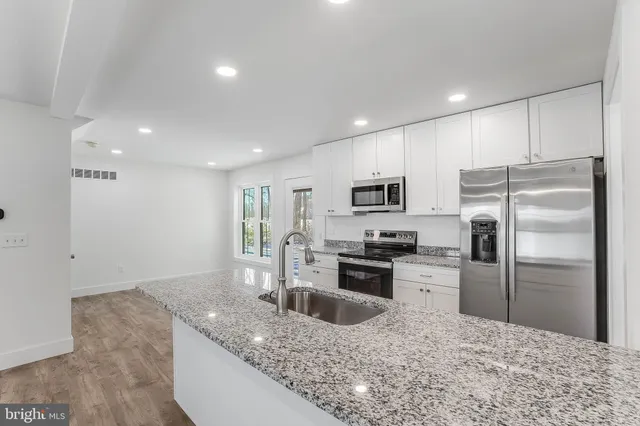 a kitchen with granite countertop a refrigerator and a sink
