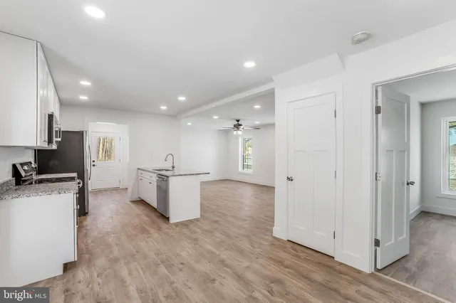 a view of a kitchen with a refrigerator and a stove top oven