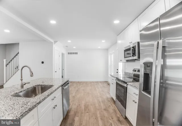 a kitchen with stainless steel appliances granite countertop a sink stove and refrigerator
