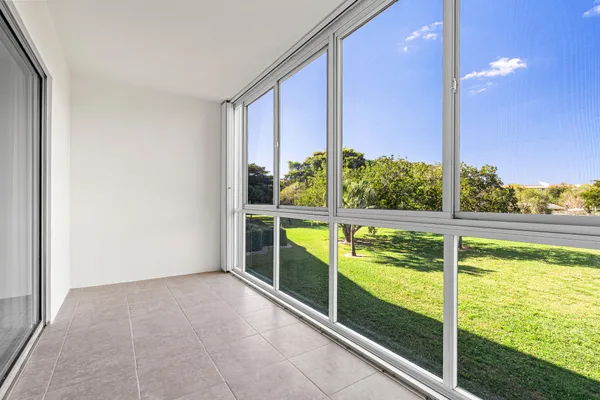 a view of an empty room with a floor to ceiling window and an outdoor kitchen