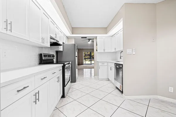 a kitchen with white cabinets and appliances