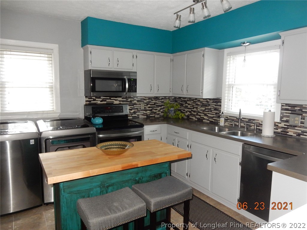 1001 Anarine Road Fayetteville, NC 28303 - Photo 8 of 24 a kitchen with a stove a sink and a microwave
