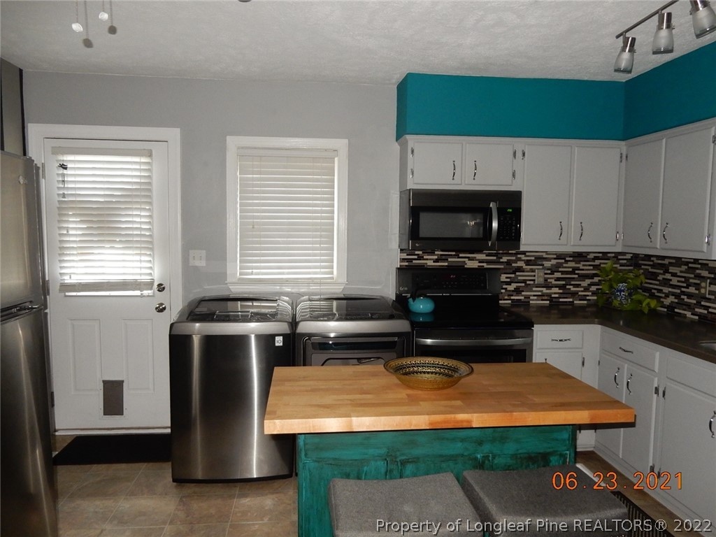 1001 Anarine Road Fayetteville, NC 28303 - Photo 9 of 24 a kitchen with stainless steel appliances a stove a sink a microwave a refrigerator and cabinets