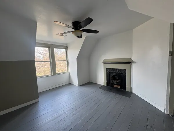 wooden floor fireplace and windows in an empty room